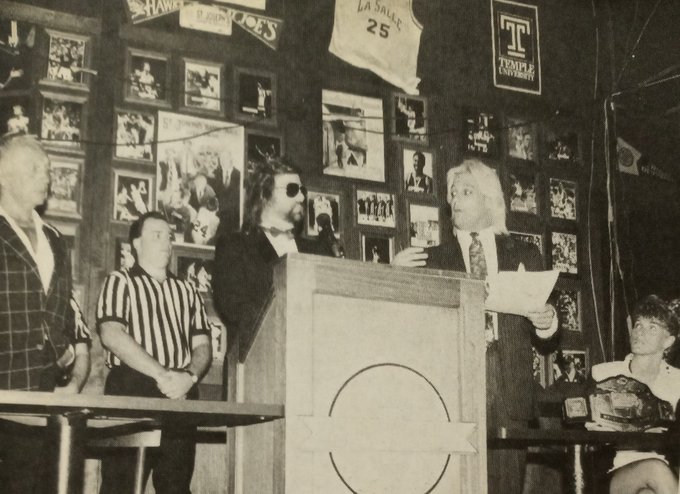 Joel Goodhart at the podium announcing the Battle of the Nature Boys match