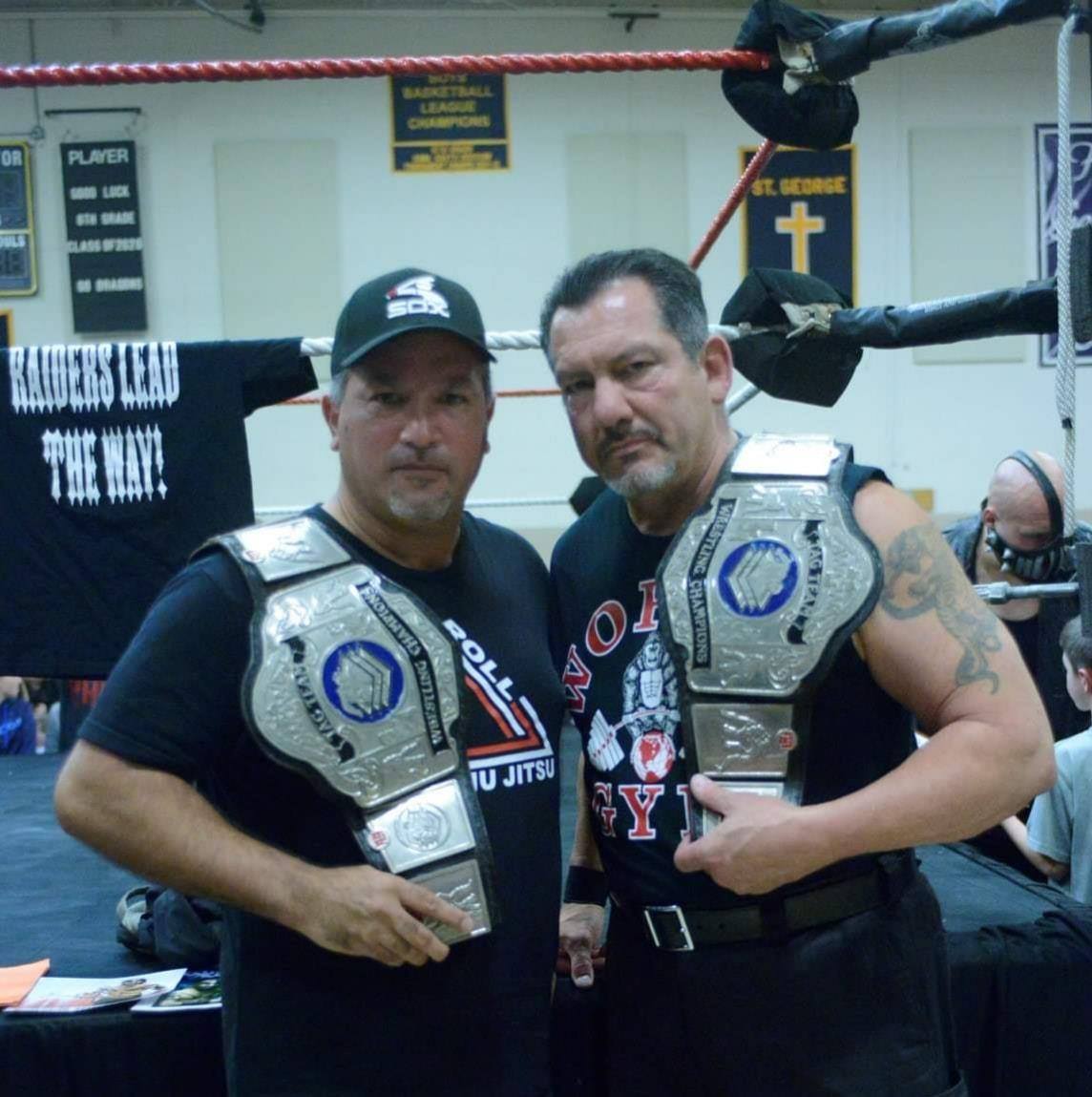 Sam Decero holding Tag Team belts with Mike Anthony